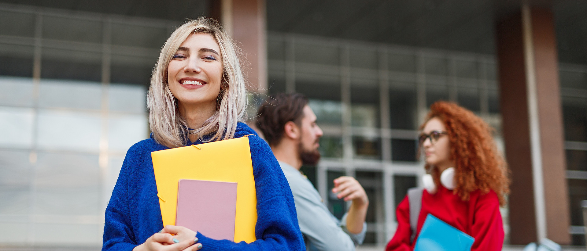 Fröhliche junge Frau bewirbt sich an einer Universität.